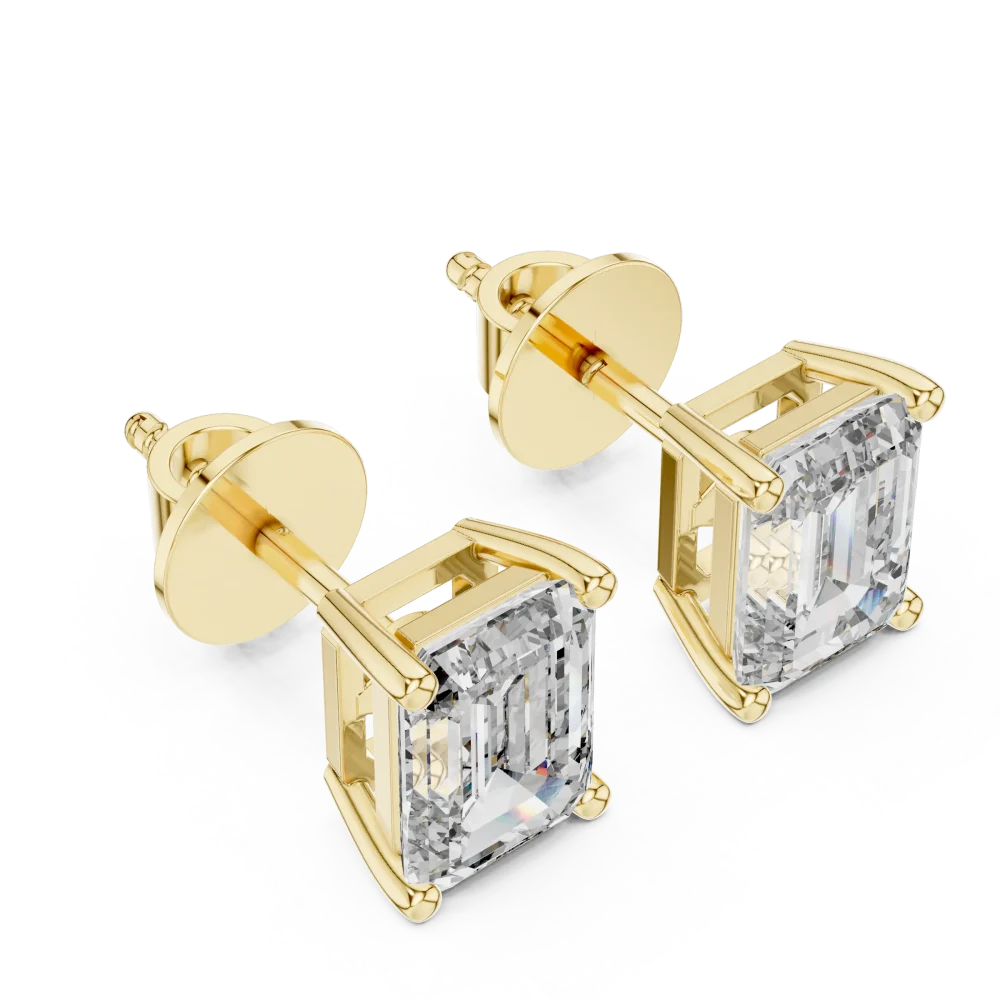 Architectural emerald cut solitaire stud earrings featuring DIAMEUR diamonds set in polished yellow gold.